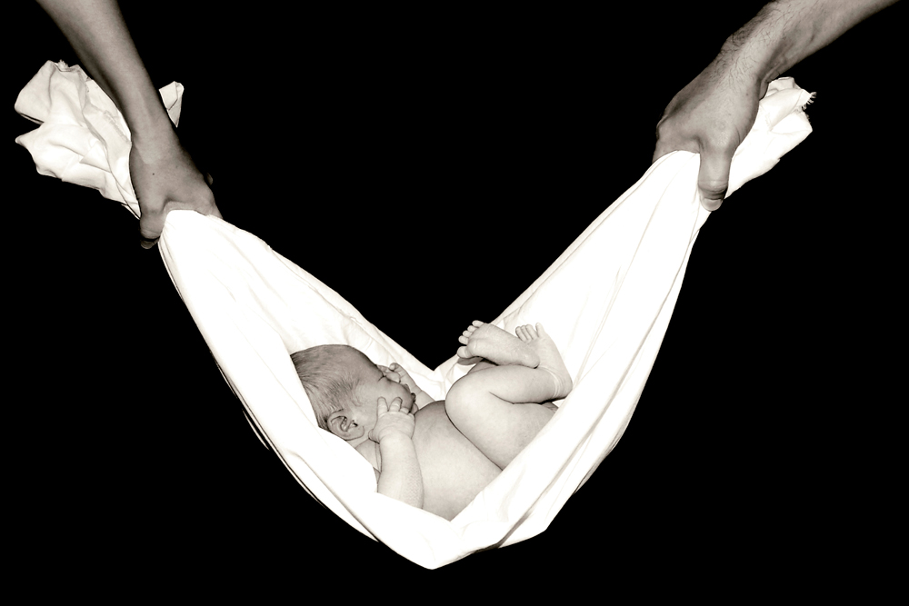 newborn in cloth hammock