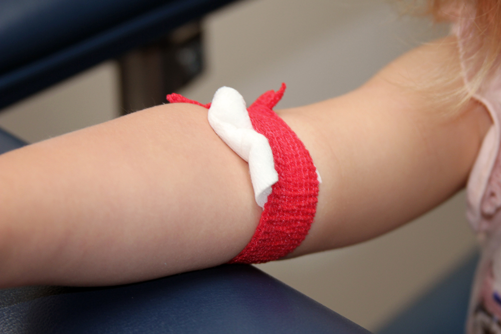 toddler getting a blood draw bandage