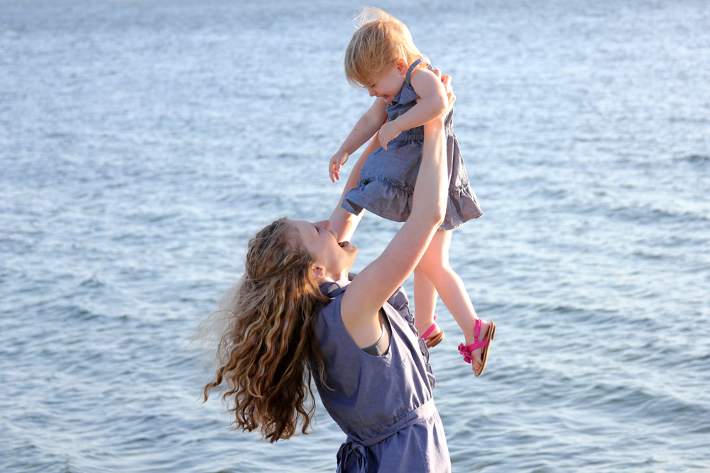 lifting up daughter in front of water