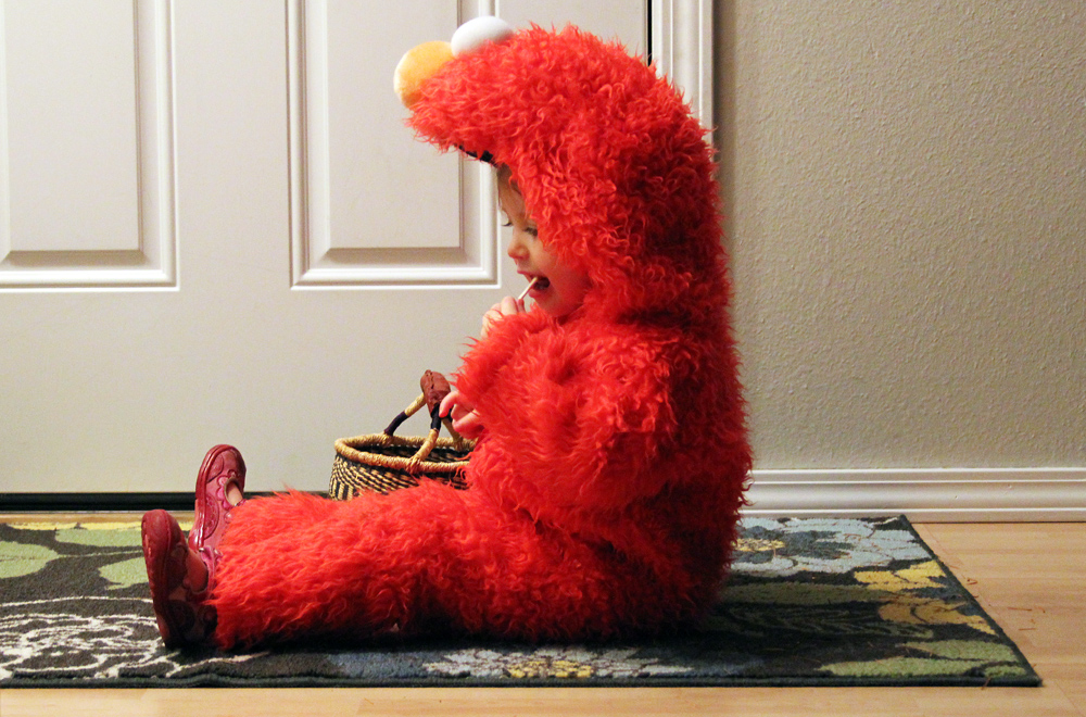 girl in elmo costume on halloween eating candy