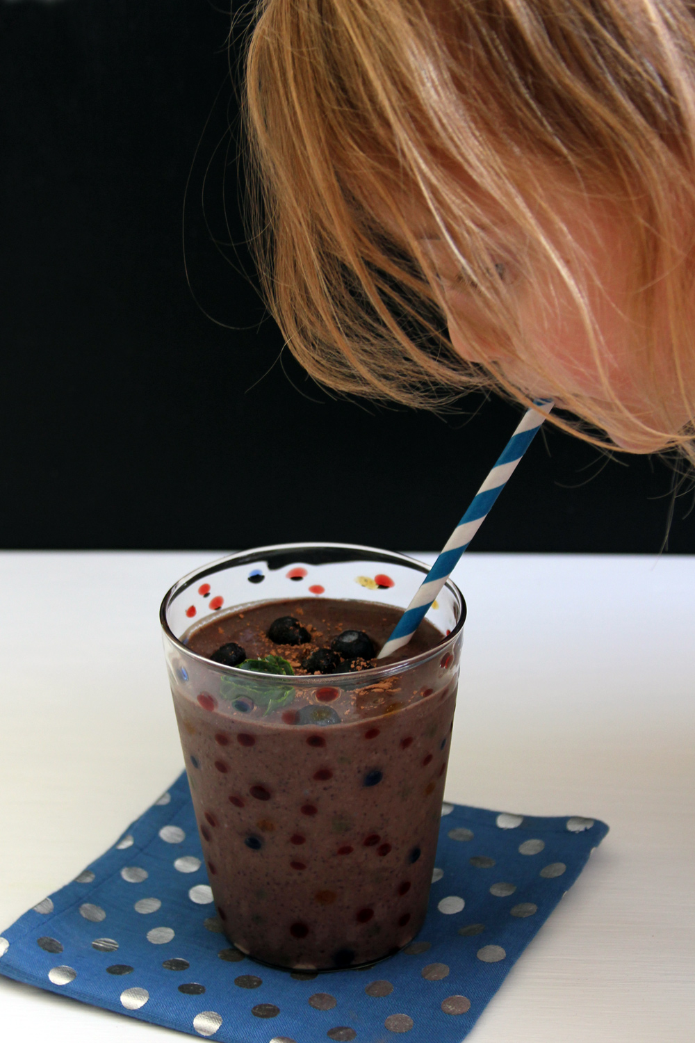 girl drinking chocolate blueberry and kale smoothie