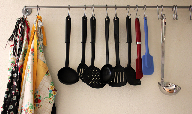 aprons and kitchen utensils hanging on wall