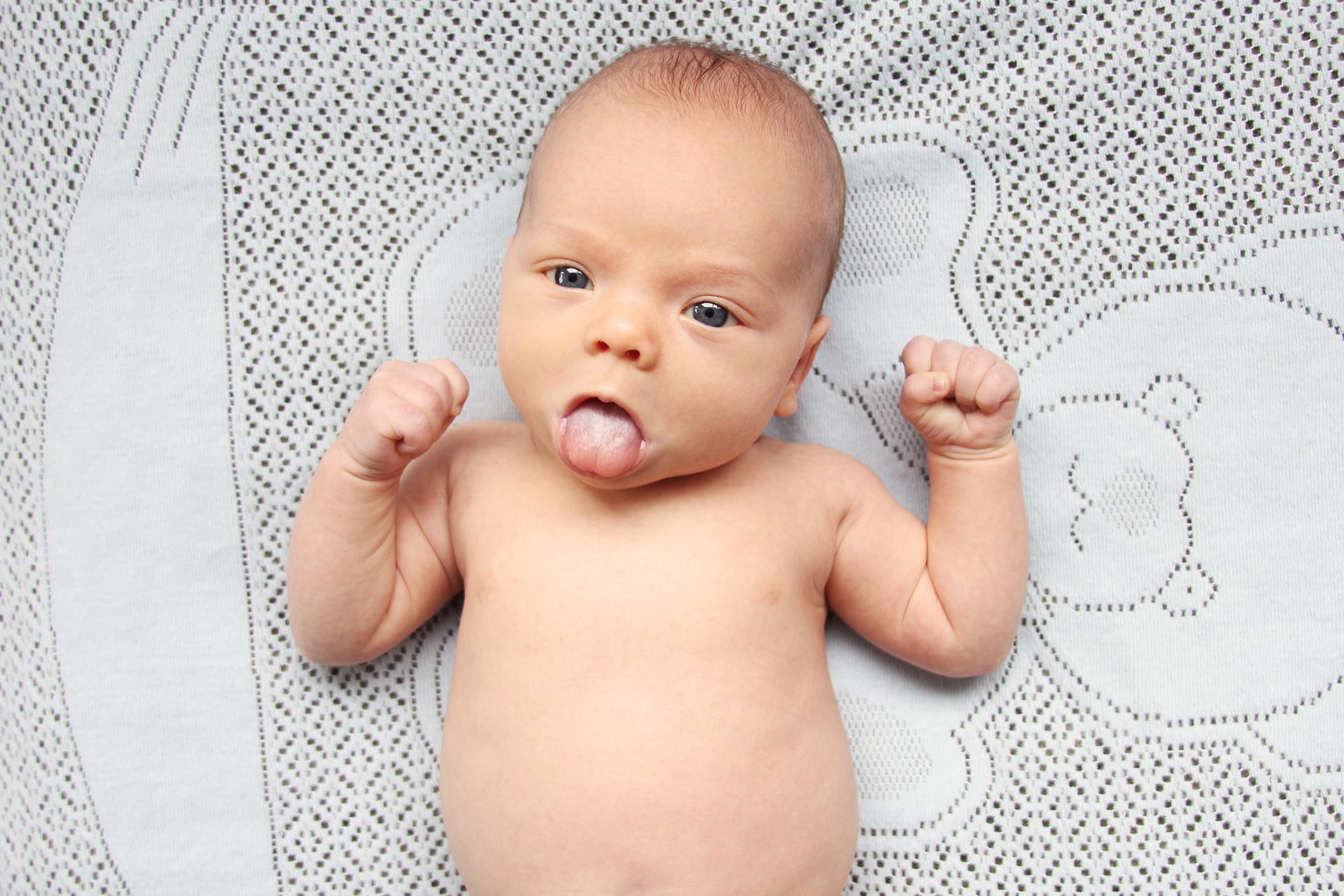 newborn baby sticking tongue out