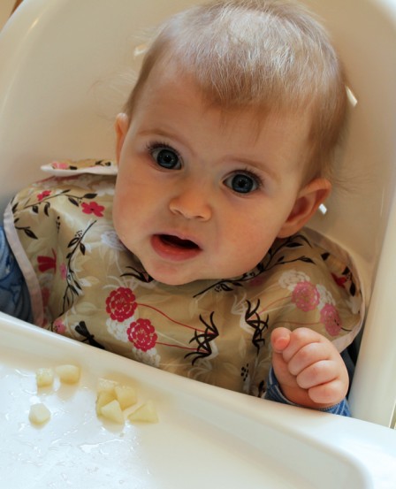 baby eating grabbing pear pieces